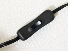 Load image into Gallery viewer, A close-up of a black inline switch with a textured plastic housing and a black cord, shown on a white textured fabric background.