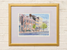 Load image into Gallery viewer, Vintage framed streetscape print of colorful historic row houses with neutral matting and gold-tone frame