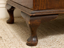 Load image into Gallery viewer, Close-up of a dark brown wooden furniture piece, showing carved legs and a textured woven rug underneath.