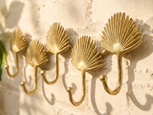 Load image into Gallery viewer, Vintage brass-tone wall hook rack with connected fan-shaped motifs and curved clothing hooks