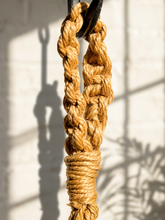 Load image into Gallery viewer, Vintage 1970s natural fiber macramé plant hanger with braided knots, twisted cord details, and tassel