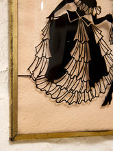 Load image into Gallery viewer, A close-up of a framed wall art piece showing a black silhouette of a woman in a layered ruffled dress on a warm beige background, with a distressed gold-toned frame.