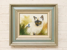 Load image into Gallery viewer, Vintage framed portrait painting of a Siamese cat watching a blue butterfly among green and golden tropical foliage