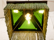 Load image into Gallery viewer, A square decorative pendant light with a fringed tiki-style design, featuring bright green geometric panels and a glowing bulb in the center.
