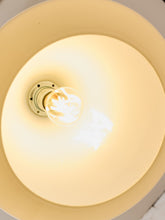 Load image into Gallery viewer, A close-up top-down view of a warm white ceiling light fixture with a glowing bulb inside a circular shade.