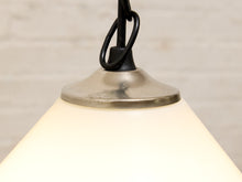 Load image into Gallery viewer, Close-up of a hanging pendant light with a warm white glass shade, a brushed metal top canopy, and a black hanging cord against a light neutral background.