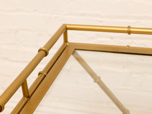 Load image into Gallery viewer, Close-up of a gold metal frame with a glass top, showing the corner joint and bamboo-inspired ring accents against a white brick wall background.