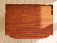 Load image into Gallery viewer, A rectangular wooden serving tray with rounded corners and a small cutout in the upper right, shown from above on a woven beige surface.