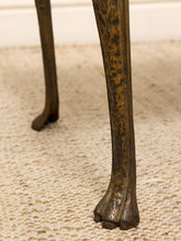 Load image into Gallery viewer, Close-up of a dark bronze or brass table leg with a clawfoot design, standing on a textured beige woven rug.