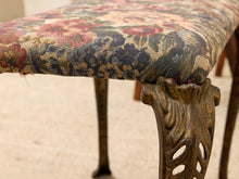 Load image into Gallery viewer, Close-up of an upholstered bench or stool with a floral woven fabric seat and carved wooden legs on a light beige floor.