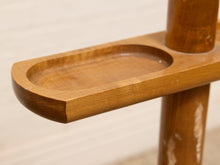 Load image into Gallery viewer, Close-up of a medium brown wooden tray or dish with a rounded rectangular shape, mounted on a wooden stand against a light off-white background.