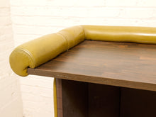 Load image into Gallery viewer, Close-up of a mid-century modern bar counter with a dark wood tabletop and a thick, padded mustard yellow leather corner armrest.