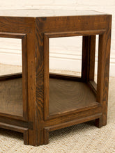 Load image into Gallery viewer, A close-up of a dark brown wooden side table with a geometric frame design, featuring a top surface, open side panels, and a lower shelf, set on a textured beige rug against a white brick wall.