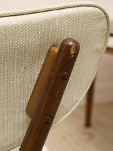 Load image into Gallery viewer, Close-up of a vintage mid-century modern chair featuring a textured light beige fabric seat, a dark brown wooden frame, and a wooden backrest support with visible wear and scratches.