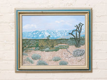 Load image into Gallery viewer, Vintage California desert landscape painting with Joshua tree, blue mountain range, desert vegetation, and silver-tone frame.
