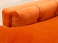 Load image into Gallery viewer, Close-up of an orange velvet upholstered sofa showing the back cushion and tufted button details.