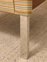 Load image into Gallery viewer, Close-up of a modern furniture leg with a hammered silver metal finish, supporting a striped upholstered seat cushion on a woven beige rug.