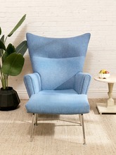 Load image into Gallery viewer, Vintage blue upholstered high-back lounge chair with angular padded arms, slender metal legs, and matching ottoman