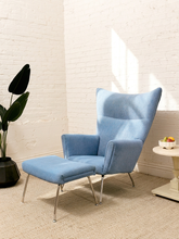Load image into Gallery viewer, Vintage blue upholstered high-back lounge chair with angular padded arms, slender metal legs, and matching ottoman
