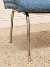 Load image into Gallery viewer, Close-up of a mid-century modern chair with a blue textured fabric seat and polished chrome legs, resting on a beige woven rug.
