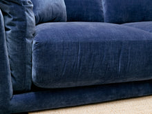 Load image into Gallery viewer, Close-up of a plush navy blue velvet sofa cushion with a textured fabric, resting on a light beige woven rug.