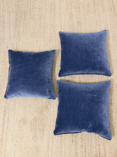 Load image into Gallery viewer, Three square navy blue velvet throw pillows arranged on a beige woven jute rug.