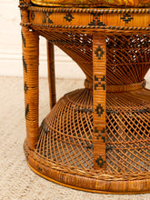 Load image into Gallery viewer, Close-up of a woven rattan or wicker chair base with geometric black and brown decorative accents, shown on a light textured rug.