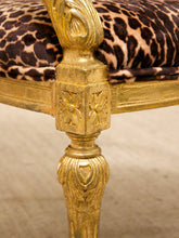 Load image into Gallery viewer, Close-up of an ornate gold-framed chair leg with carved floral details and a leopard-print upholstered seat cushion.