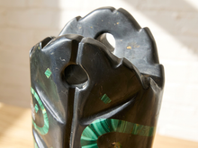 Load image into Gallery viewer, A close-up of a carved black stone or wood vessel with green spiral accents, photographed indoors against a light neutral background.