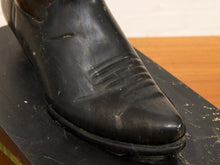 Load image into Gallery viewer, A close-up of a black leather dress shoe boot on a dark display base, showing the toe and vamp with visible wear and scuffs.