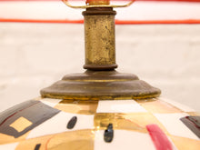 Load image into Gallery viewer, Close-up detail of a vintage-style table lamp base featuring a brass-toned metal neck and a glossy, hand-painted mosaic globes in cream, gold, black, and red.