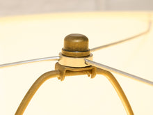 Load image into Gallery viewer, Close-up detail of a brass lamp shade finial and support structure, showing a warm gold-toned dome cap and metal arms against a softly lit cream background.