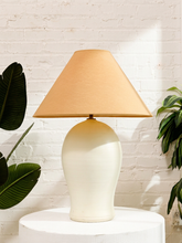 Load image into Gallery viewer, Vintage table lamp with large rounded white sculptural base, subtle horizontal detailing, and warm brown tapered fabric shade