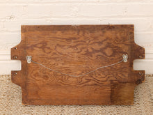 Load image into Gallery viewer, A rustic wooden board with a rich brown wood grain pattern, featuring two metal wire hangers with decorative silver-colored ends on the back, set against a white brick wall and woven jute rug.