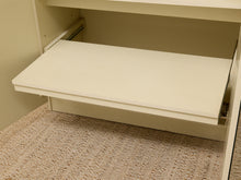 Load image into Gallery viewer, A close-up of a cream-colored drawer front with a pull handle, shown partially extended inside a matching cream-colored cabinet or shelf unit. The bottom of the unit is covered with a textured beige carpet.