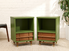 Load image into Gallery viewer, Pair of green and wood nightstands with open upper storage, warm wood-front lower compartments, slender pulls, and tapered wood legs