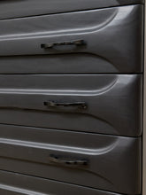 Load image into Gallery viewer, Close-up of a dark gray dresser or cabinet with three drawers, each featuring a curved metallic pull handle.