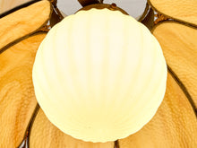 Load image into Gallery viewer, A close-up of a vintage stained glass pendant light featuring a large, ribbed, pearlescent white glass center globe surrounded by warm amber and gold petal-shaped glass panels.