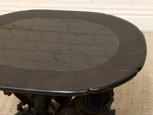 Load image into Gallery viewer, A close-up of a dark oval table top with a glossy black finish and a raised border, showing a reflection of a brick wall. The table base is partially visible below, and the setting appears to be a neutral indoor surface.