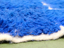 Load image into Gallery viewer, Close-up of a blue shaggy rug with a white tufted edge over a green floor.