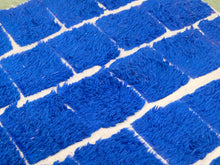 Load image into Gallery viewer, A close-up of a bright blue shaggy rug with a white brick or tile pattern.