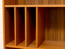 Load image into Gallery viewer, Close-up of a wooden shelving unit with three vertical dividers and a wood-grain back panel, shown against a light off-white wall.
