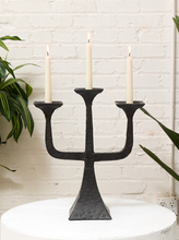 Load image into Gallery viewer, Vintage Brutalist three-arm iron candelabra with square candle platforms, curved sculptural arms, dark finish, and flared pedestal base