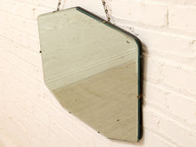 Load image into Gallery viewer, Vintage octagonal mirror with a dark green-tinted glass frame, hanging from a metal chain against a white brick wall.