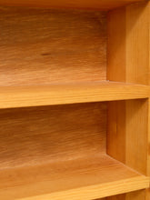 Load image into Gallery viewer, Close-up of a wooden bookshelf with three shelves, showing the warm honey-toned wood grain and corner construction.