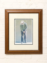 Load image into Gallery viewer, The Putt framed golf art print depicting a golfer lining up a putt, with neutral matting and a warm wood frame