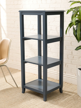 Load image into Gallery viewer, A three-tier wooden shelving unit in a dark blue-gray finish, shown in a styled room setting with a white brick wall, beige rug, a chair, and a potted plant.