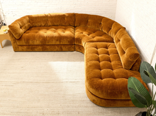 Load image into Gallery viewer, Prima curved sectional sofa in Thriller Amber with golden amber upholstery, deep button-tufted seats, channel-tufted back cushions, and rounded silhouette