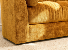 Load image into Gallery viewer, Close-up of a mustard yellow textured fabric sofa corner on a light beige carpet.
