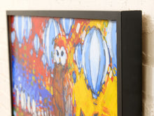 Load image into Gallery viewer, A framed abstract painting featuring a stylized owl, shown hanging on a textured off-white wall. The artwork has bold brushstrokes in yellow, blue, red, and white, enclosed in a thick black frame.
